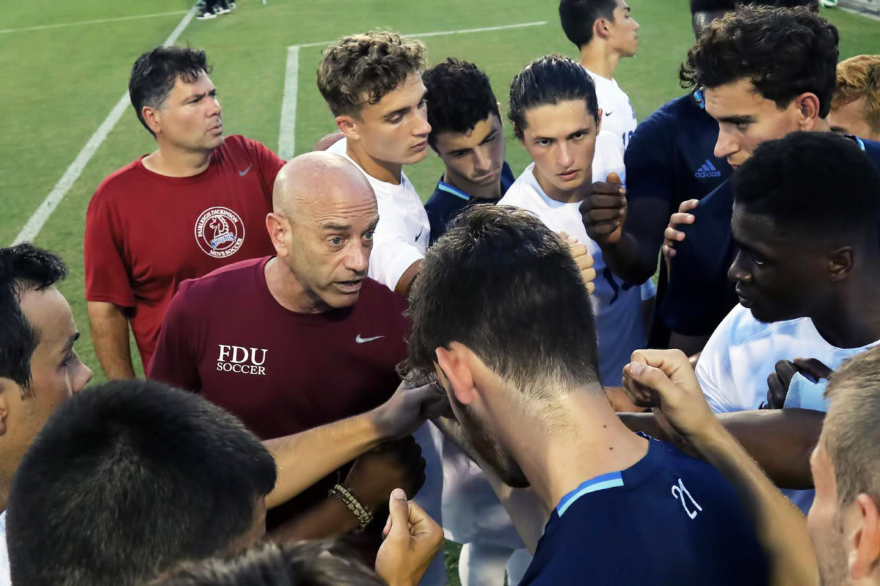 Men’s soccer head coach Seth Roland talks to his team.