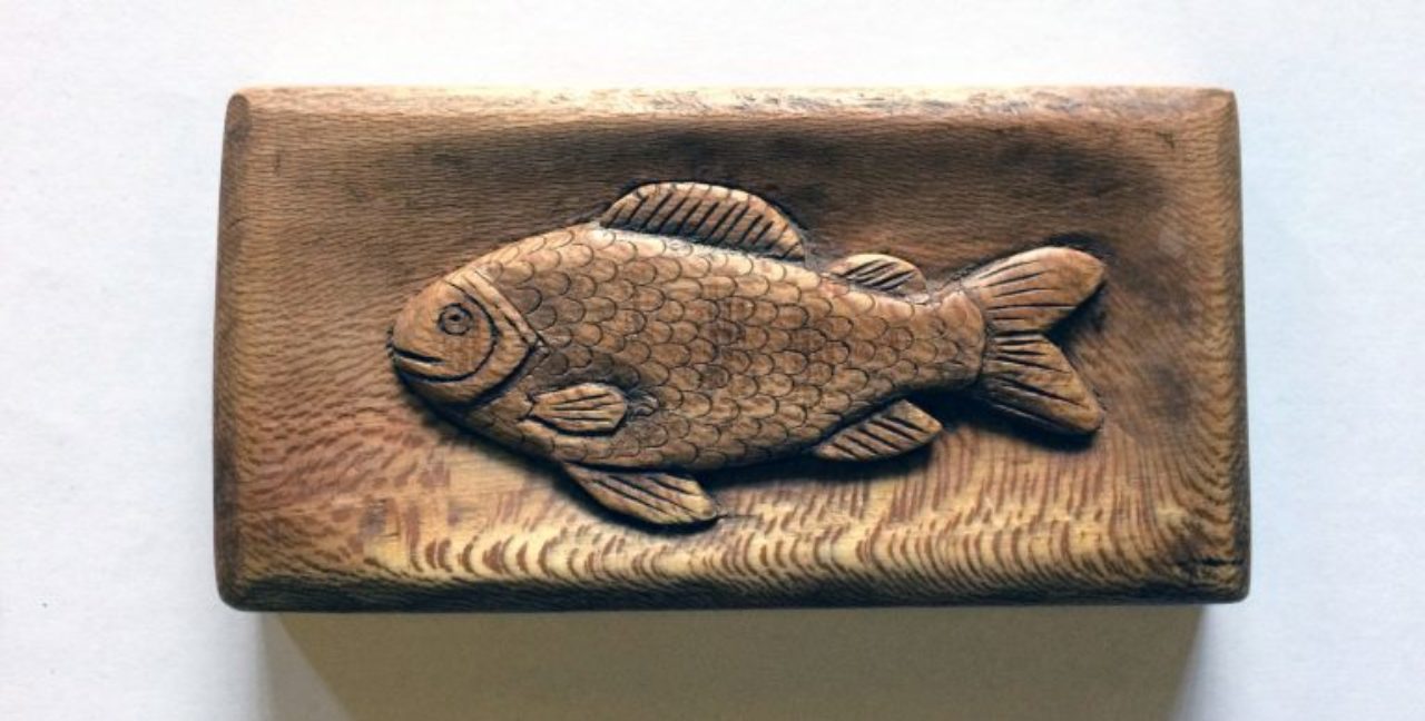 Wroxton College groundskeeper Robert Denton spends his free time making wood carvings, like this fish, and ornate walking sticks.