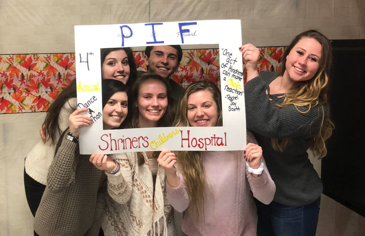students holding "pay it forward" sign