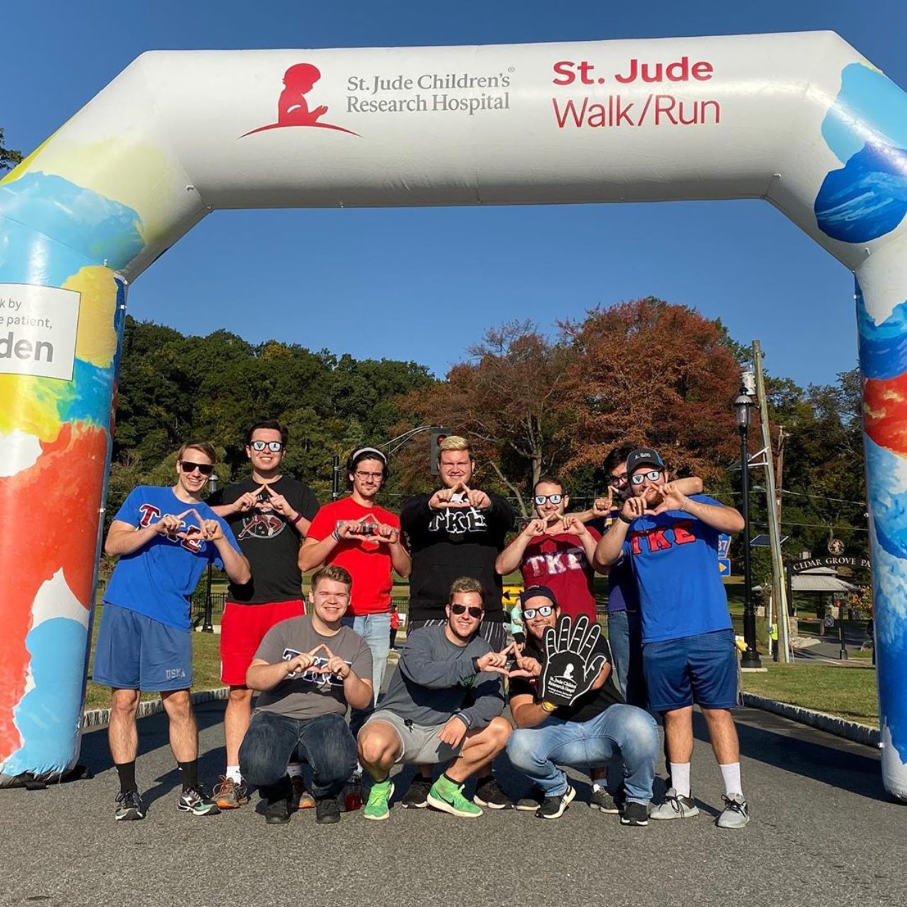 Tau Kappa Epsilon members pose in front of an inflatable arch that reads, "St. Jude Children's Research Hospital. St. Jude Walk/Run