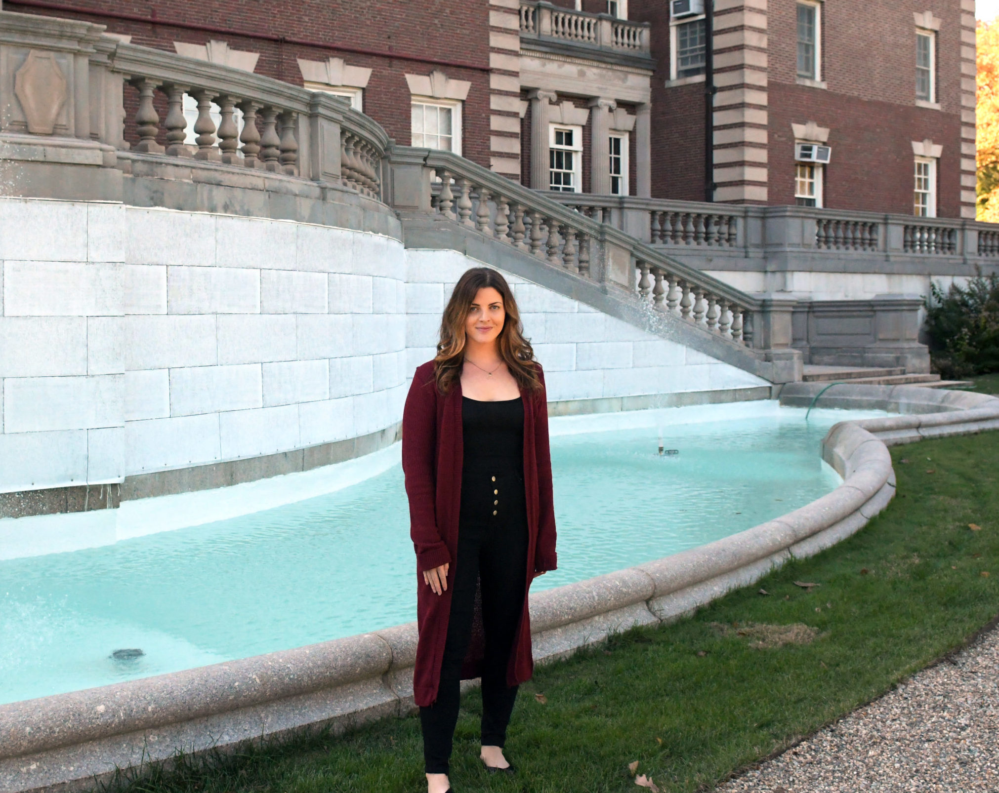 Kaity stands in front of a fountain behind Hennessy Hall at FDU's Florham Campus.