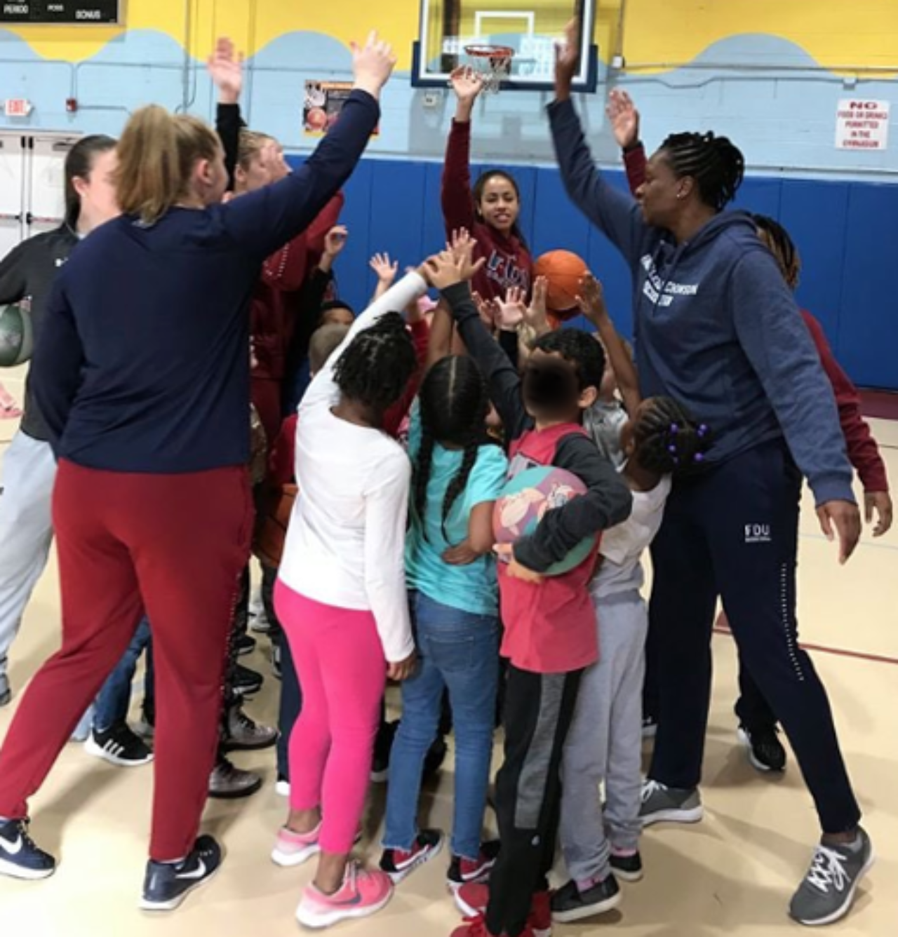 Knights women's basketball members high five children