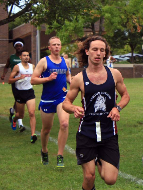 Duerr runs in a cross country race wearing a jersey that reads "Fairleigh Dickinson Cross Country"