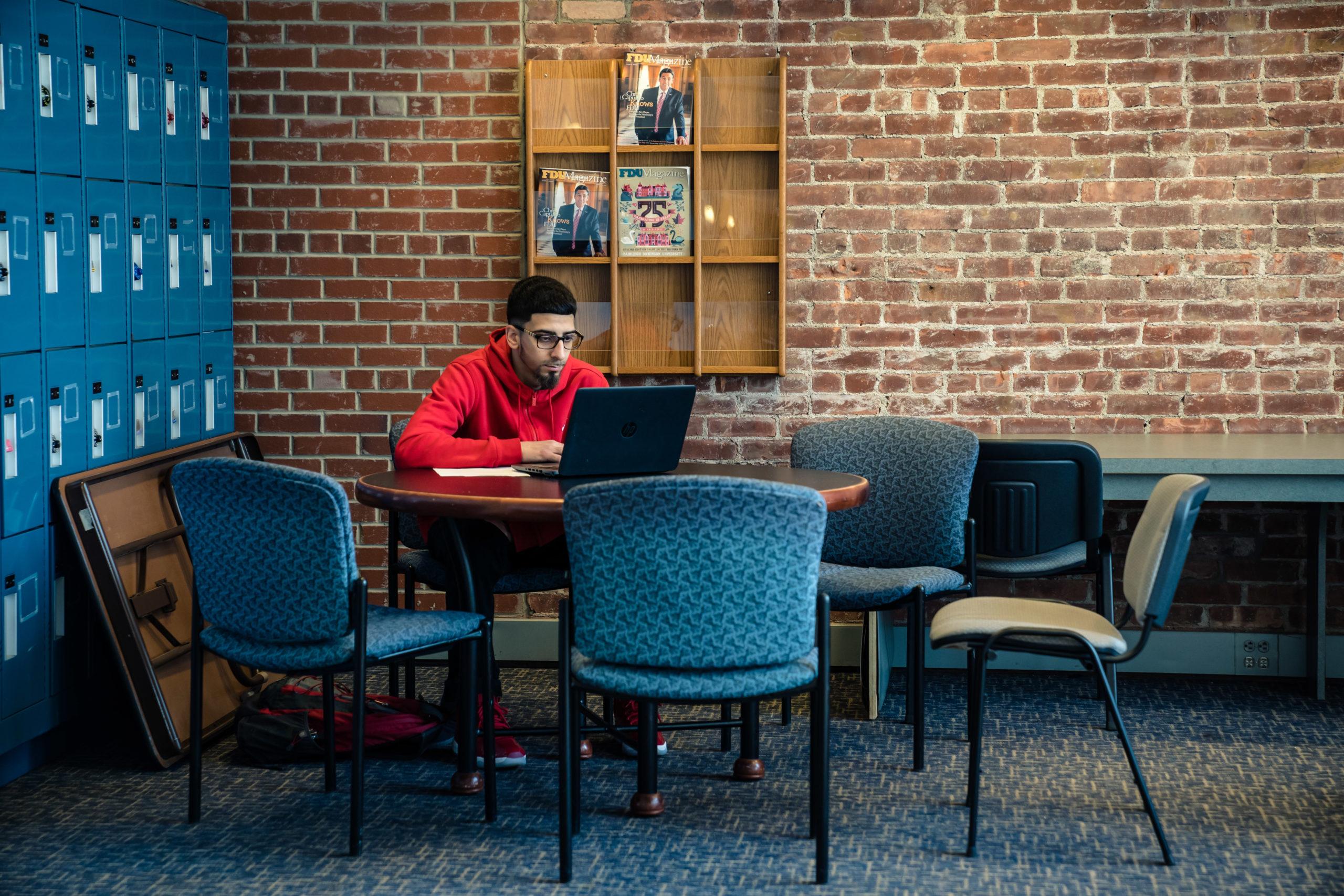 A student works on a laptop at an empty table