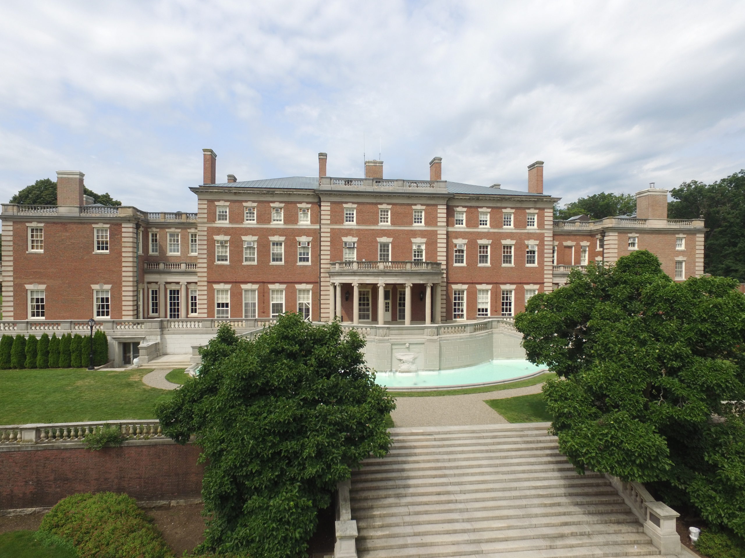 Hennessy Hall seen from behind, with a fountain and garden before it.