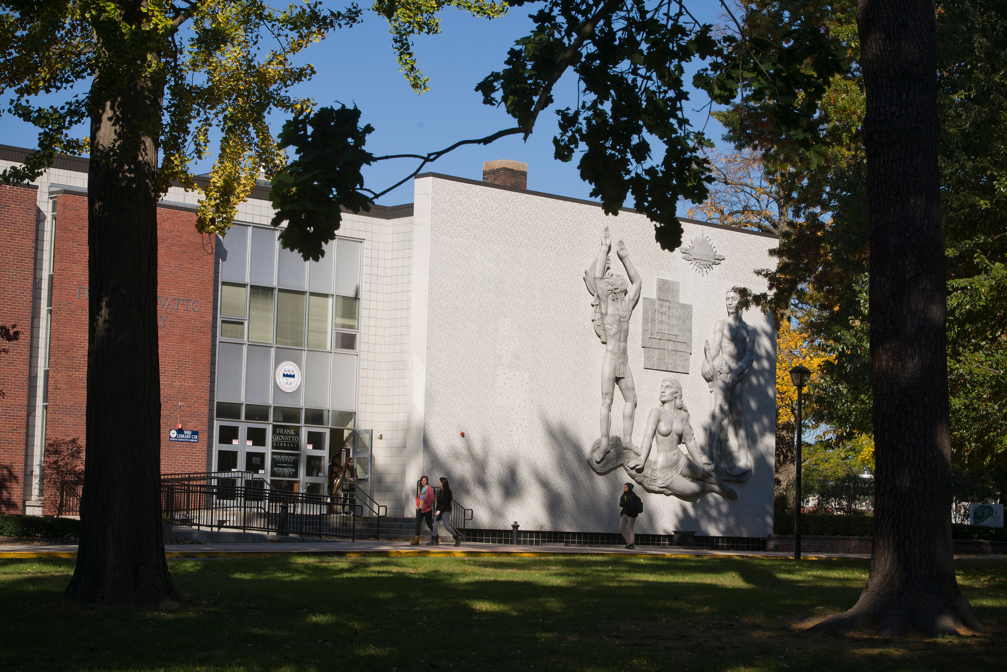 A building with trees and people in front of it.
