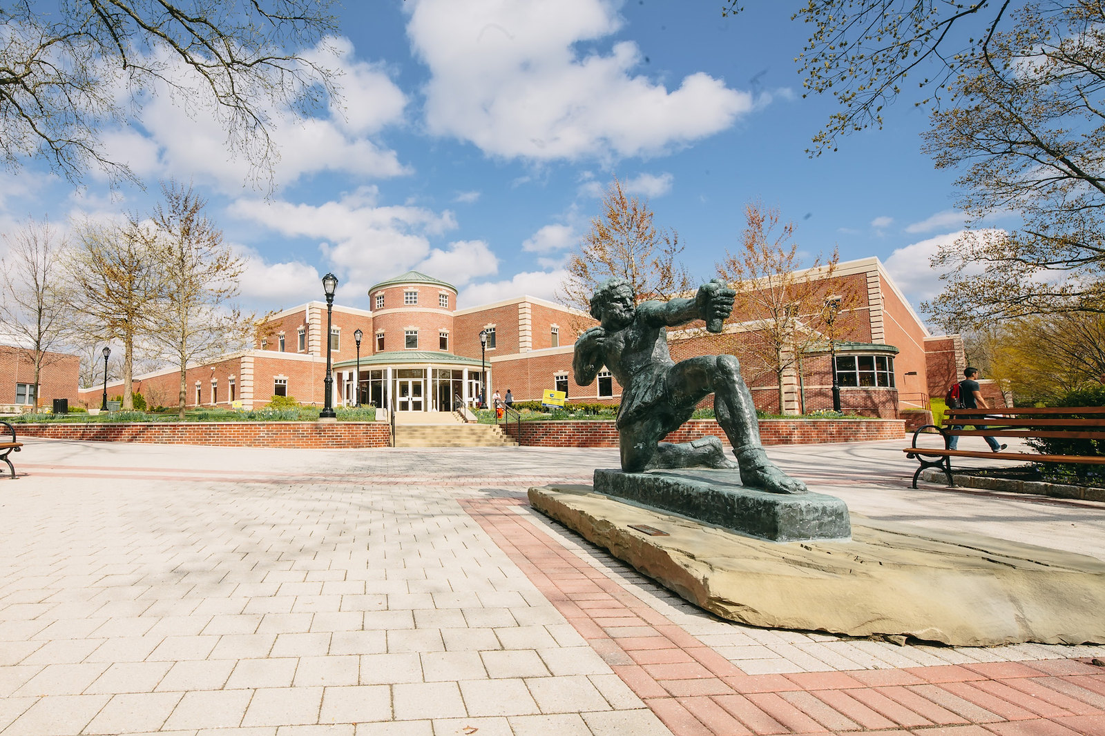 A green statue of Ulysses stands in front of a building.