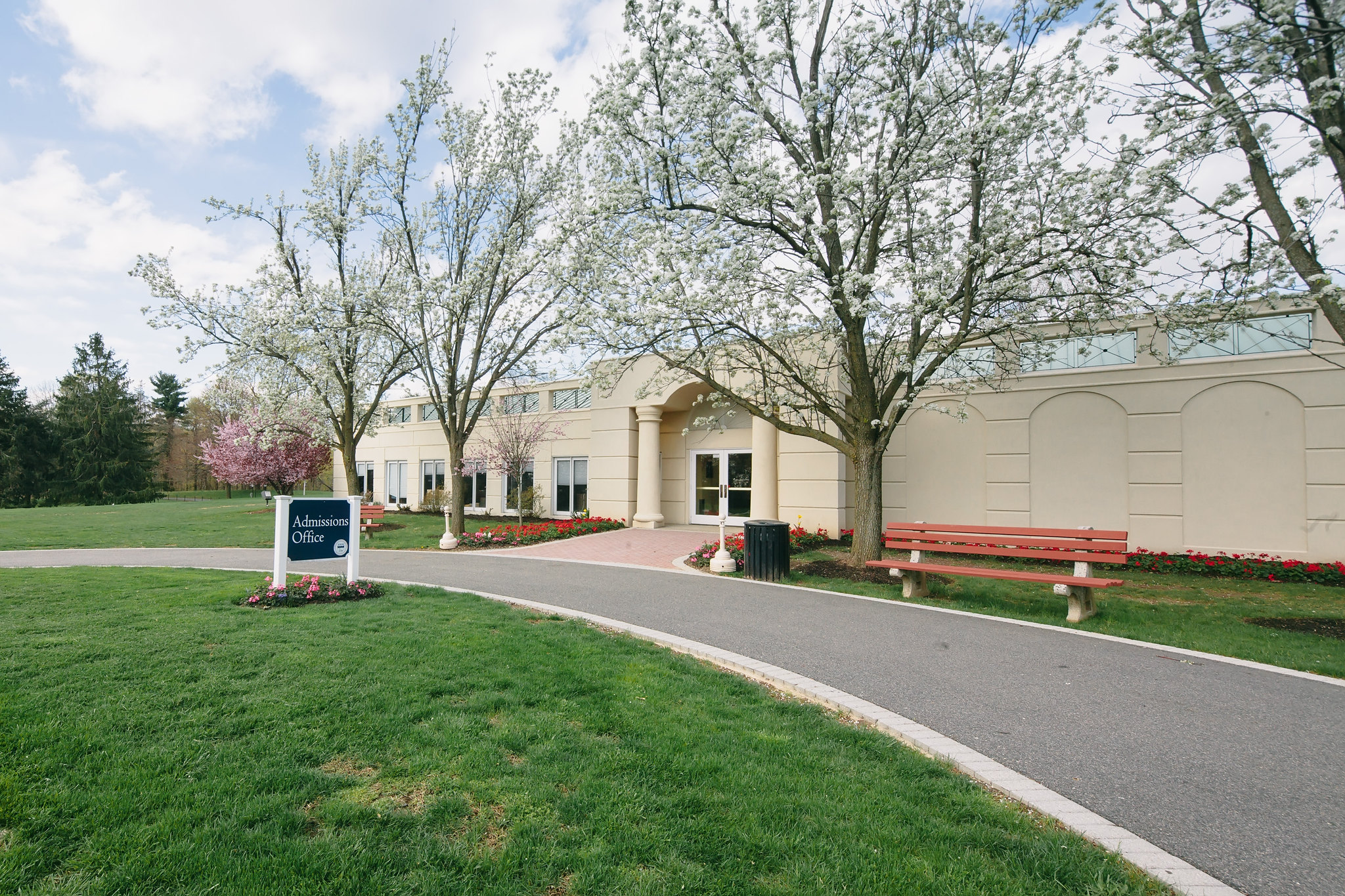 A building with three trees in front of it and a sign that says 