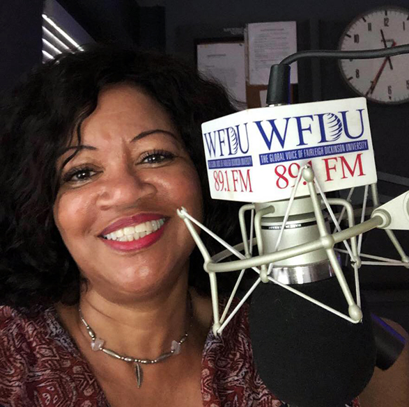 A woman sits behind a WFDU microphone.