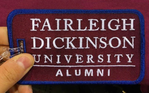 An alumni luggage tag in the FDU colors