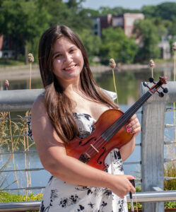 Cassandra Laman poses with her violin in front of the Hackensack River after performing at the Metropolitan Campus. 