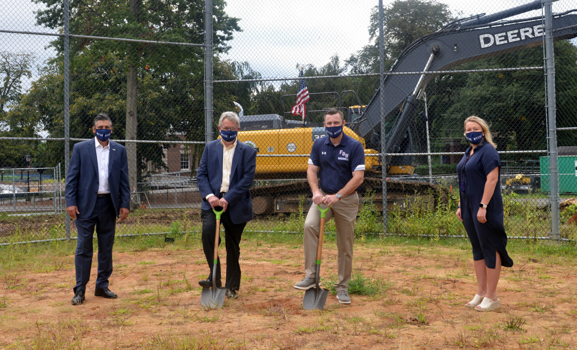 President Capuano, Vice President for Facilities & Auxiliary Services Dick Frick, Head Baseball Coach Jamie Quinn and Director of Athletics Jenn Noon stand on the location of the future Naimoli Field. Frick and Quinn hold shovels.