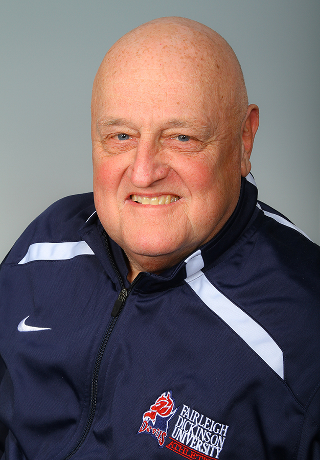 Portrait of Roger Kindel. A man in a blue zipper jacket with an FDU Devils logo on the chest. 