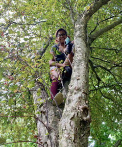 Tiffanie as young adult climbing in a tree. 