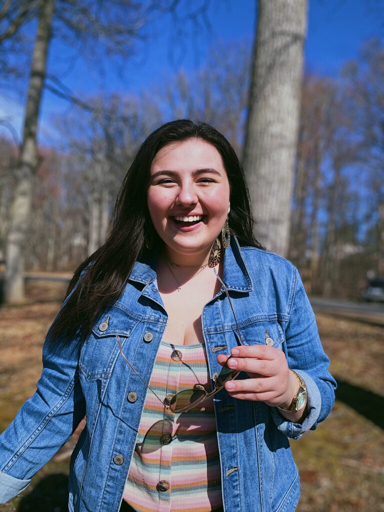 Portrait of a young woman standing outside.