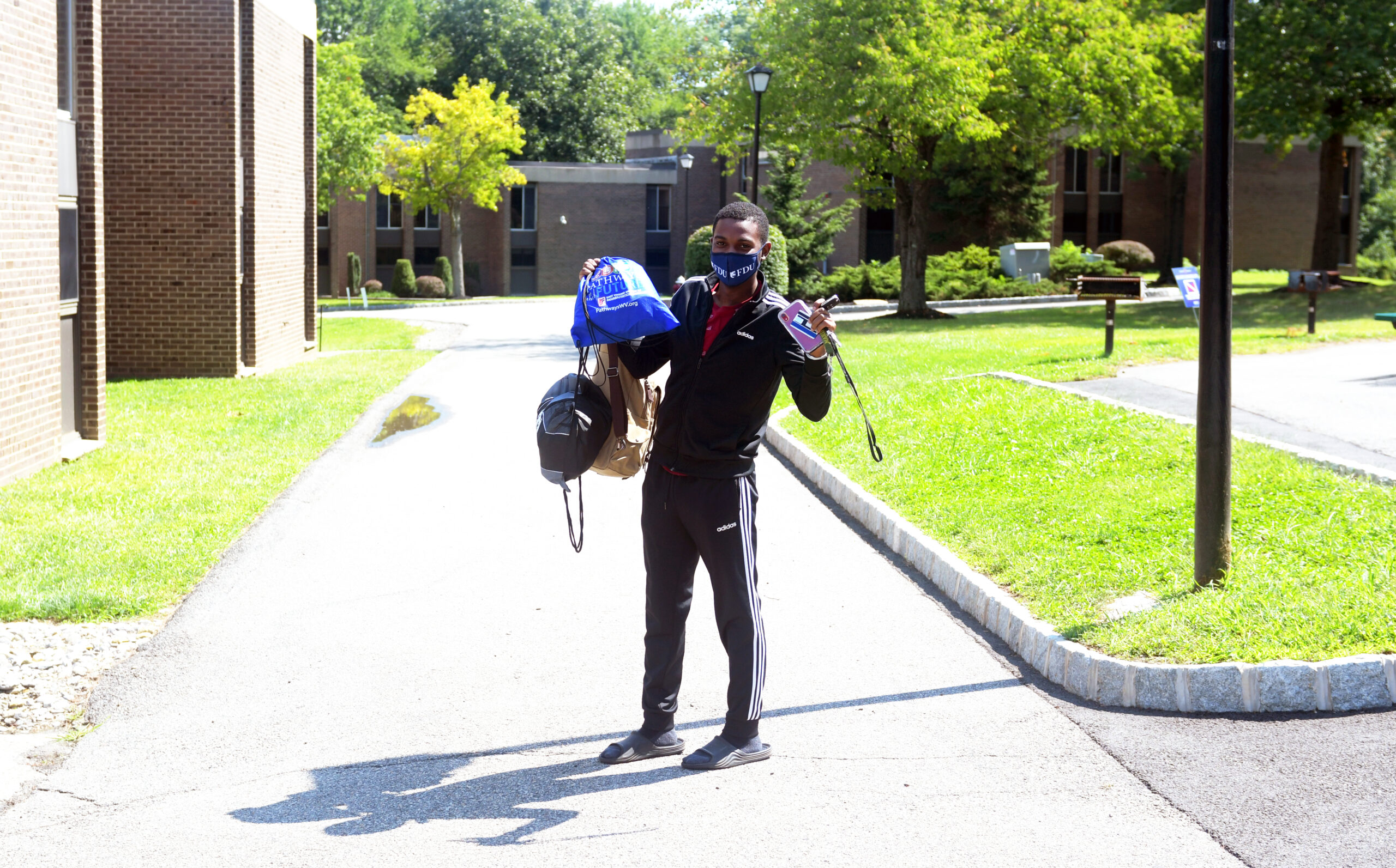 A student in a mask holds up bags.