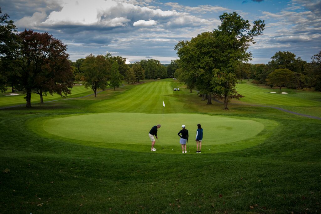 Golfers putting on a golf course green.