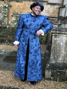 A man in medieval clothes poses outside of Wroxton Abbey.