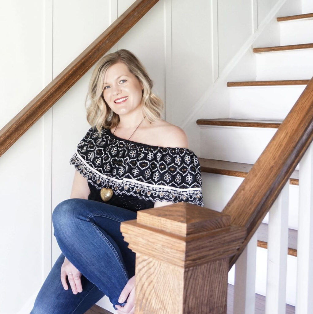 A woman sits on a wooden staircase.