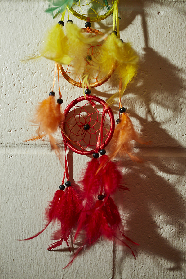 A colorful dream catcher hands on a wall.