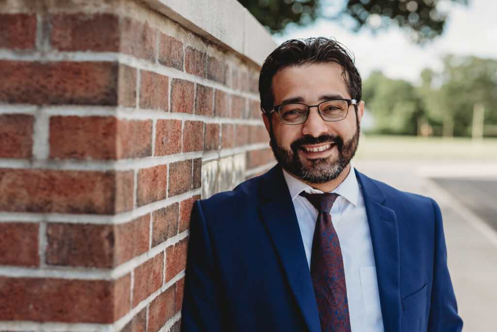 Photo of Angel Santiago next to a brick wall