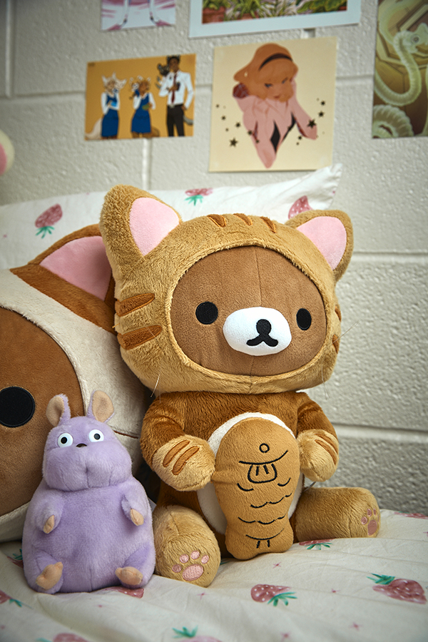 A pile of stuffed animals on a dorm bed.