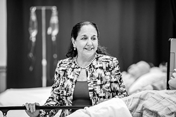 Portrait of a woman standing amid nursing equipment.