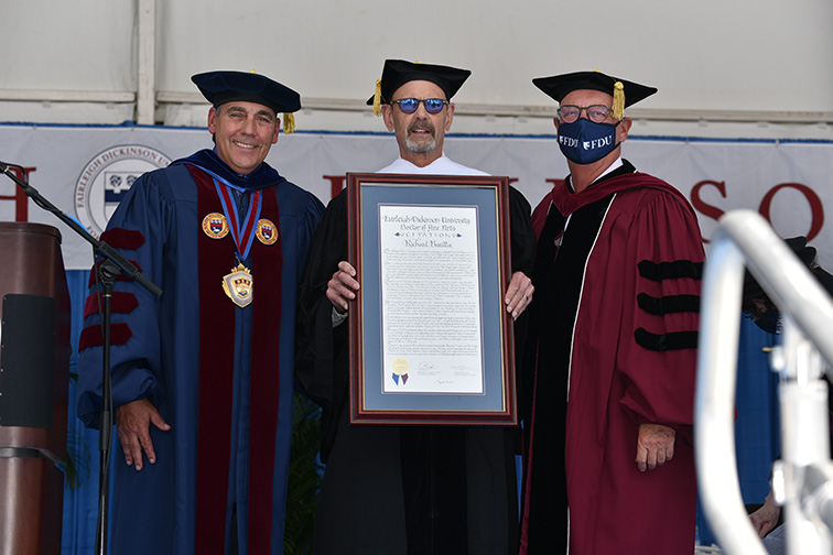 Richard Baratta stands with FDU administrators and shows off his honorary degree citation.