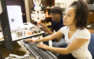 Two students work on a computer in a tech lab.
