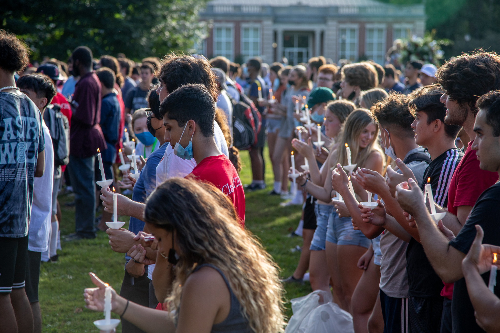 A group of students participate in a candlelight ceremony.