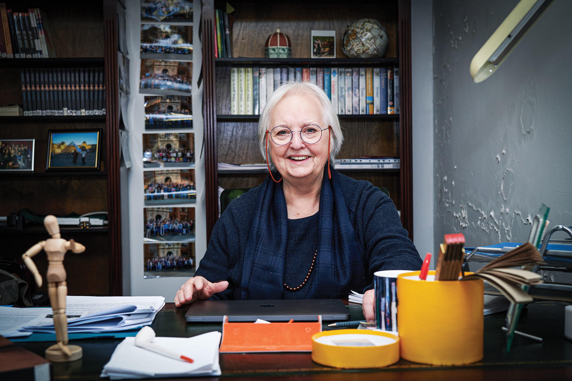 A female professor sits at her desk.