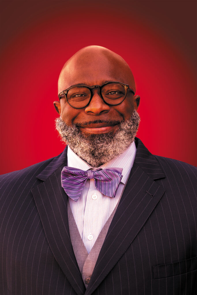 Portrait of a smiling man wearing a suit and bowtie.