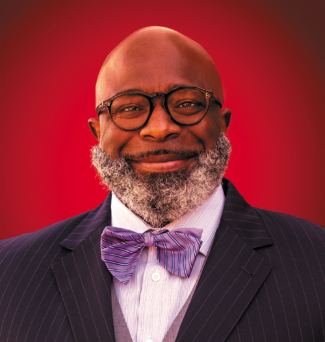 Portrait of a smiling man wearing a suit and bowtie.