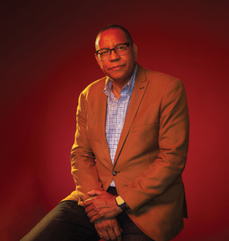 Portrait of a man wearing glasses, dressed in business casual attire.