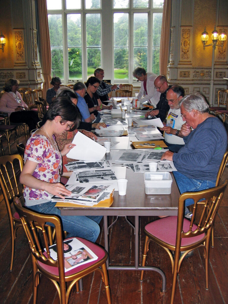 A group of scholars sit at a table, working on a project.