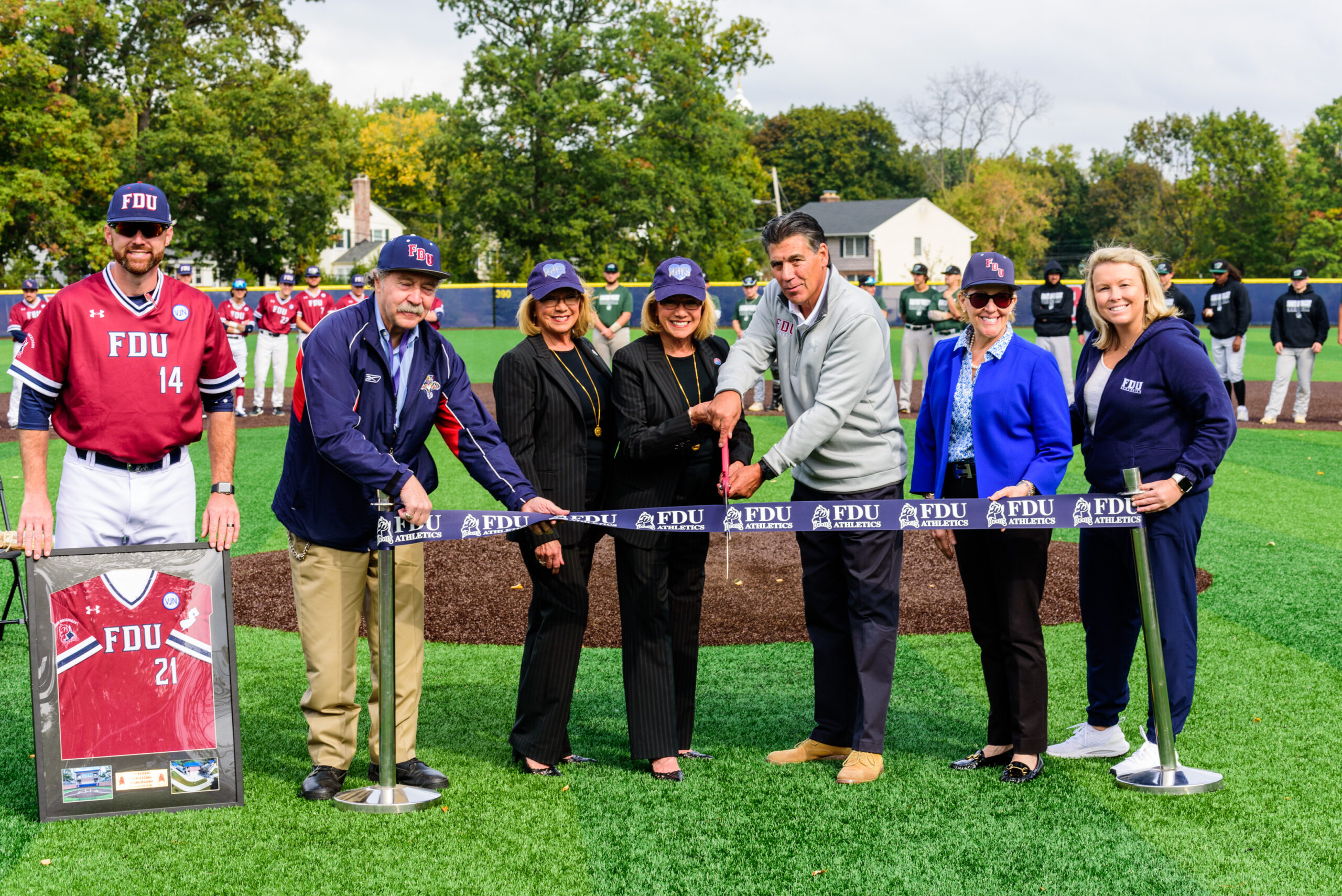 Dignitaries stand behind a ribbon about to be cut, to commemorate the opening of the Vincent J. and Lenda F. Naimoli Ballpark.