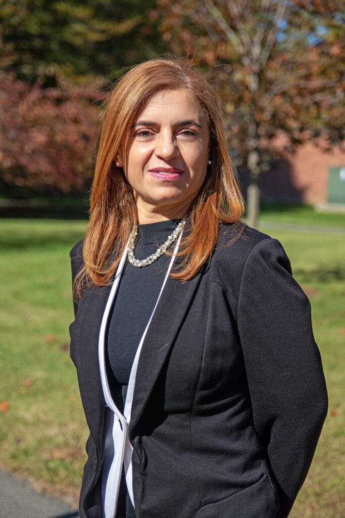 A woman dressed in business attire stands outside for a portrait.