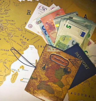 A map with foreign currency and passport atop it.