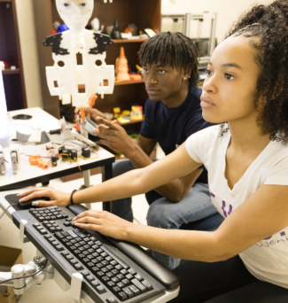 Two students work on a computer in a tech lab.