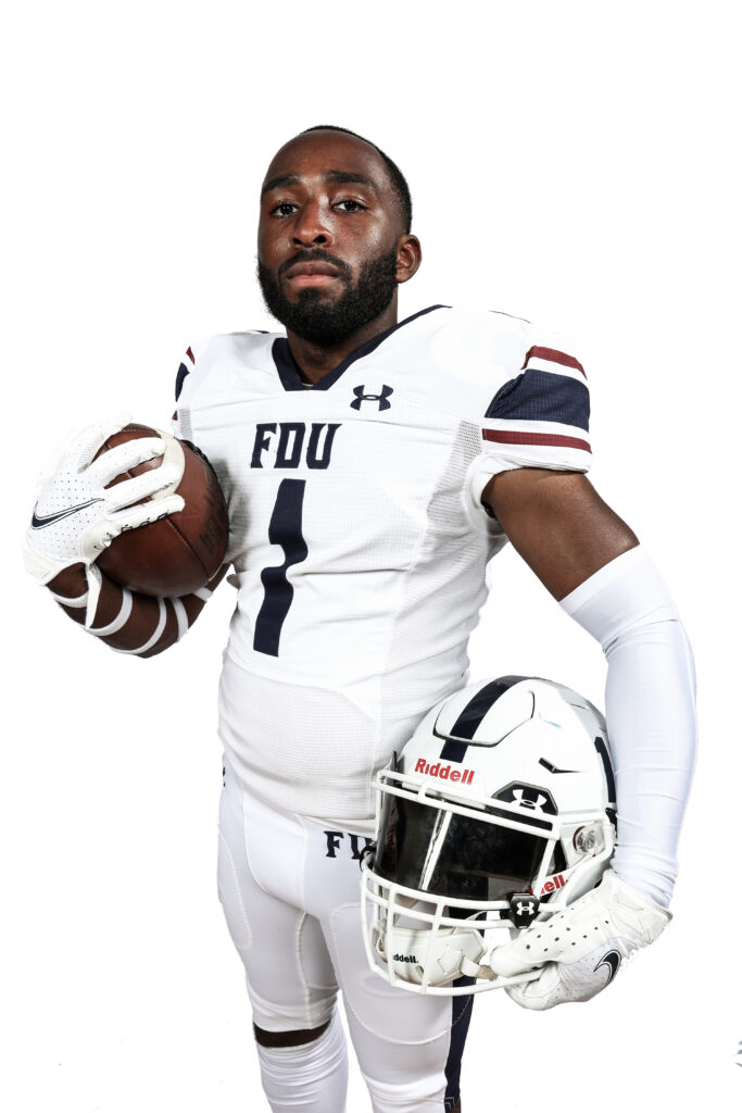 Al Blackman in his Devils football uniform holding a football and helmet. 