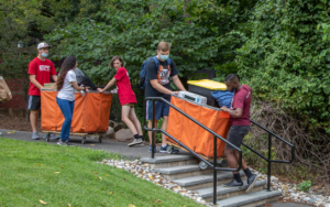 Students maneuver carts full of dorm essentials down the stairs to the residence halls.