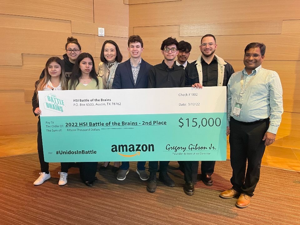 Students pose with large check