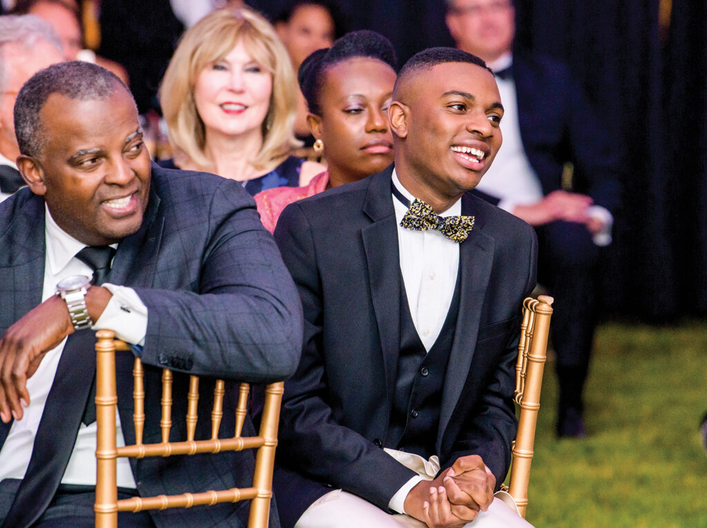 A table of folks in formal wear at a benefit gala.