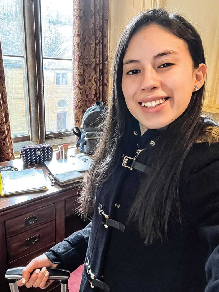 Selfie of a young woman. Her desk is visible in the background.