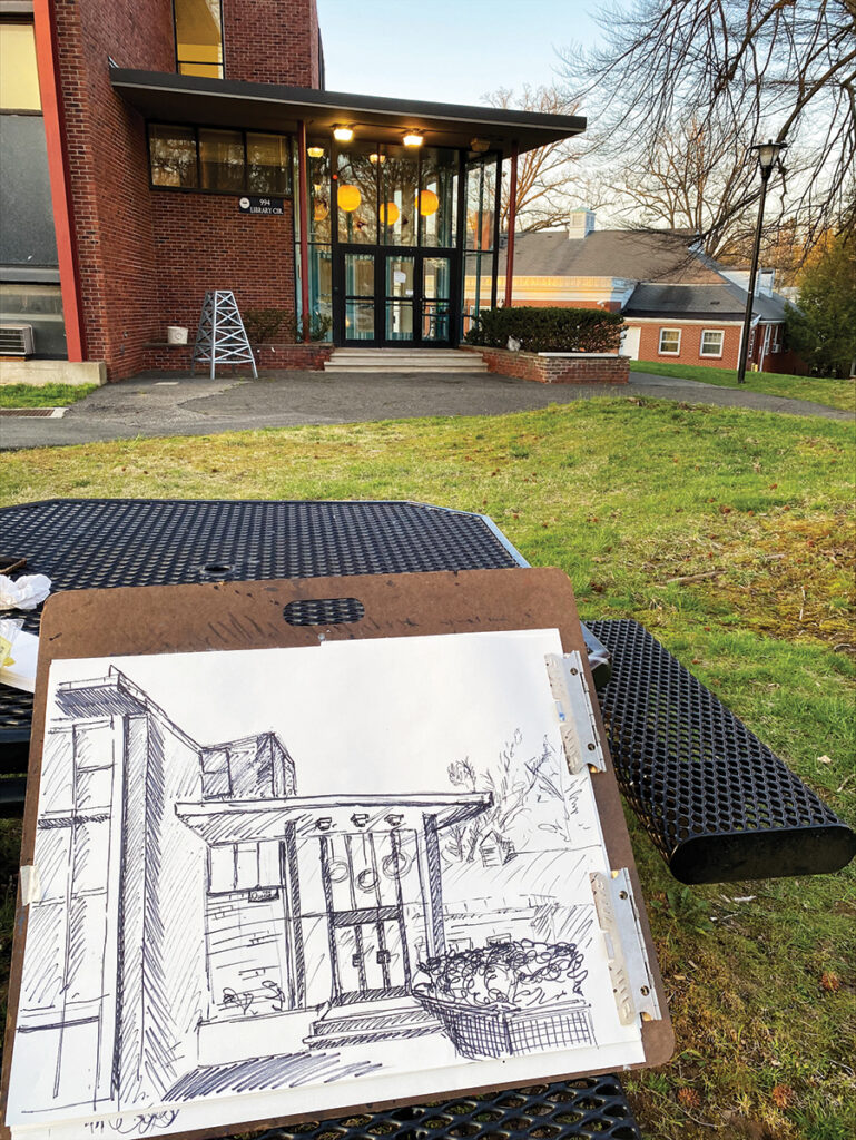 A photo of a sketch of campus landscapes and a building.