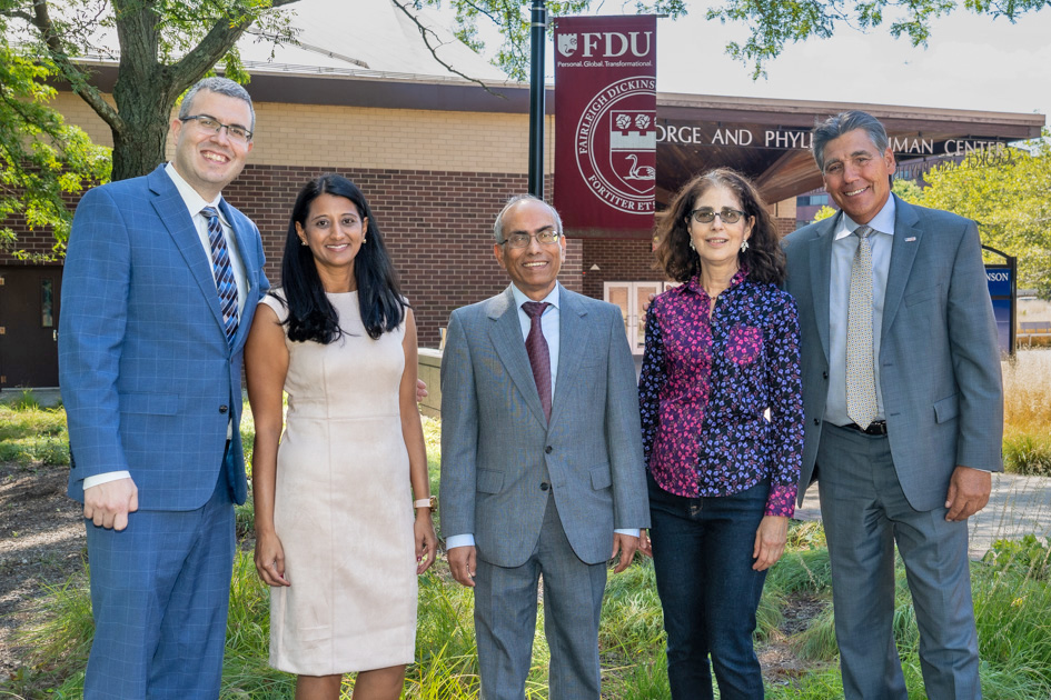 Five faculty members stand in a line and pose for a photo.