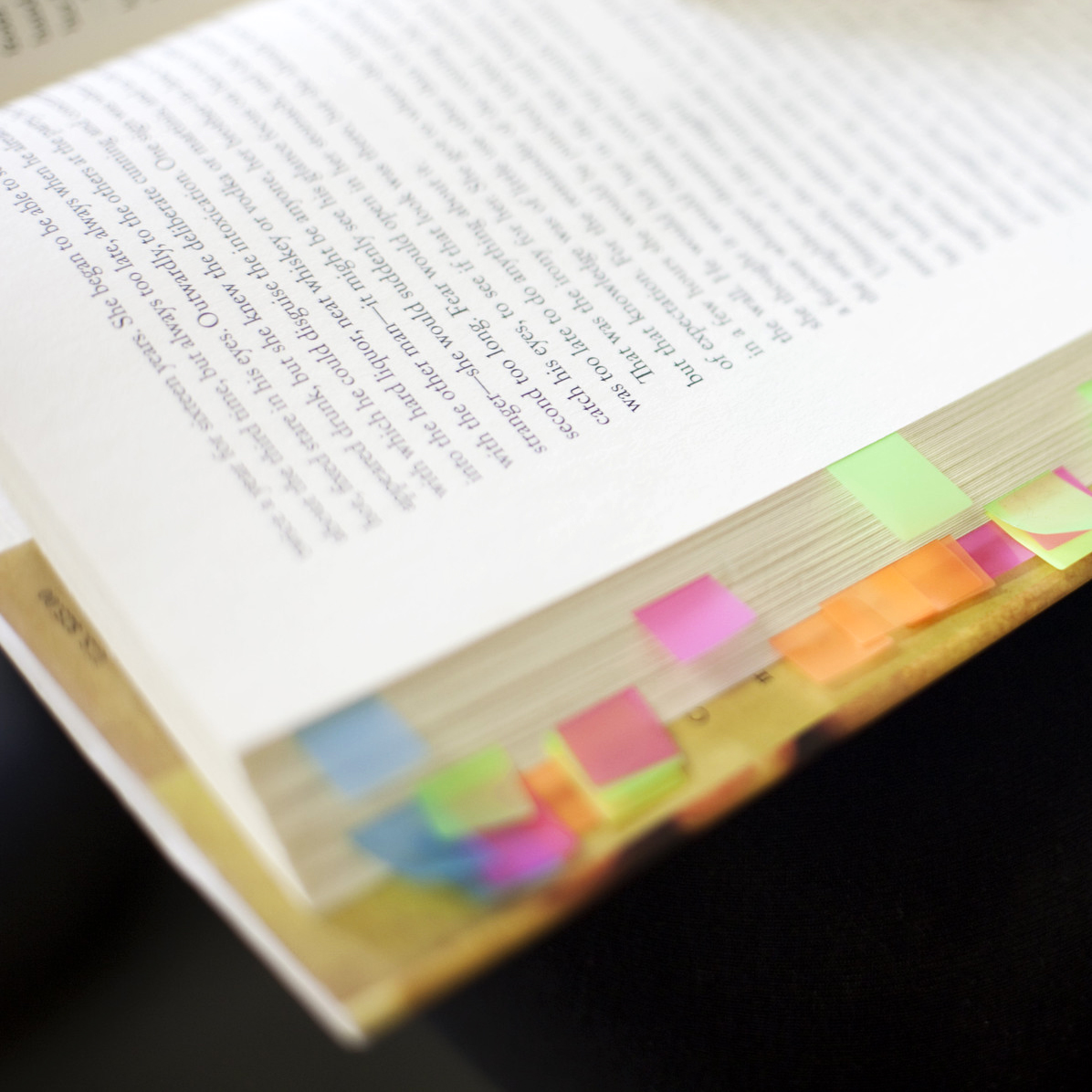 An open book with multicolored sticky tabs.