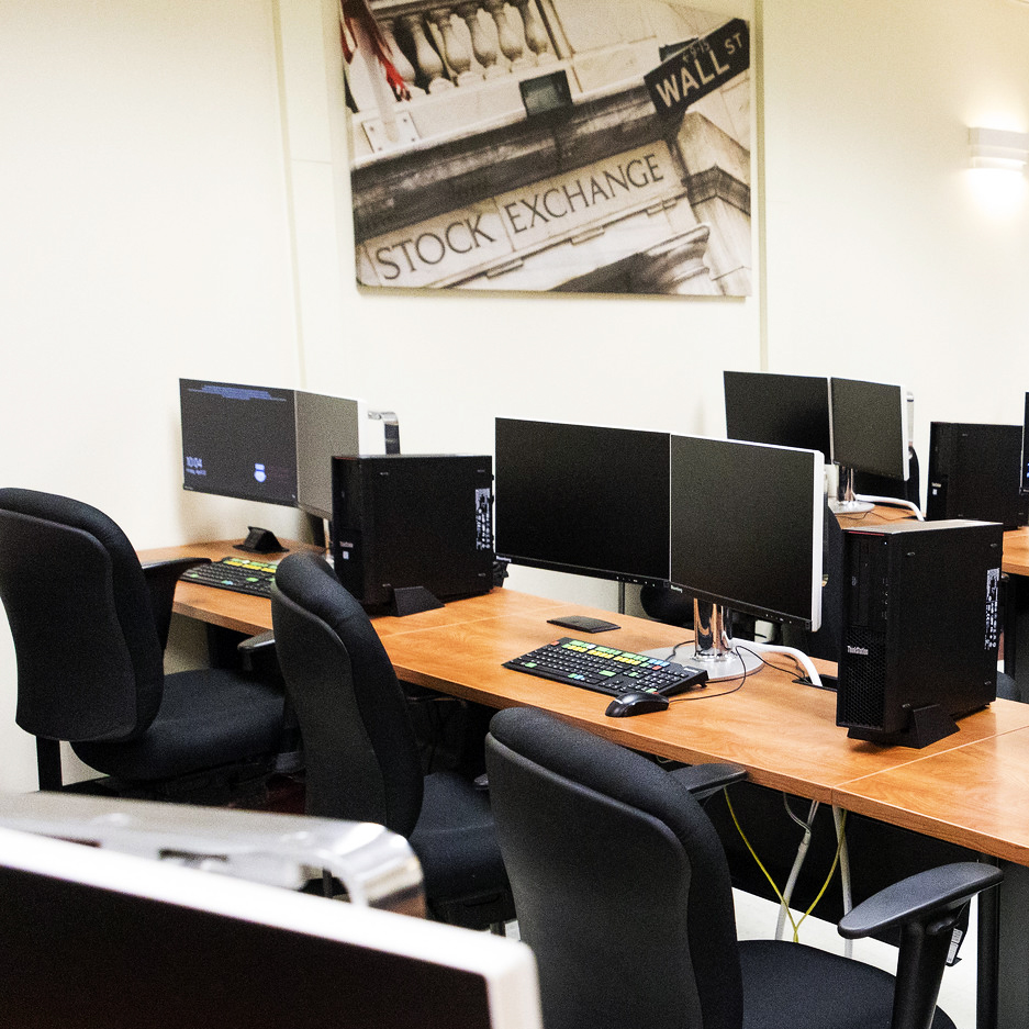 A business class with computers on a desk.