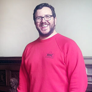 Portrait of a man wearing a Royal Shakespeare Company sweatshirt.