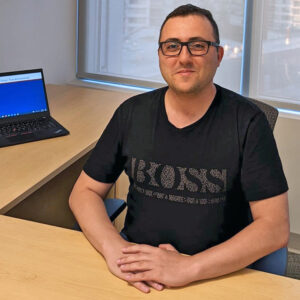 Portrait of a man, sitting at a desk.